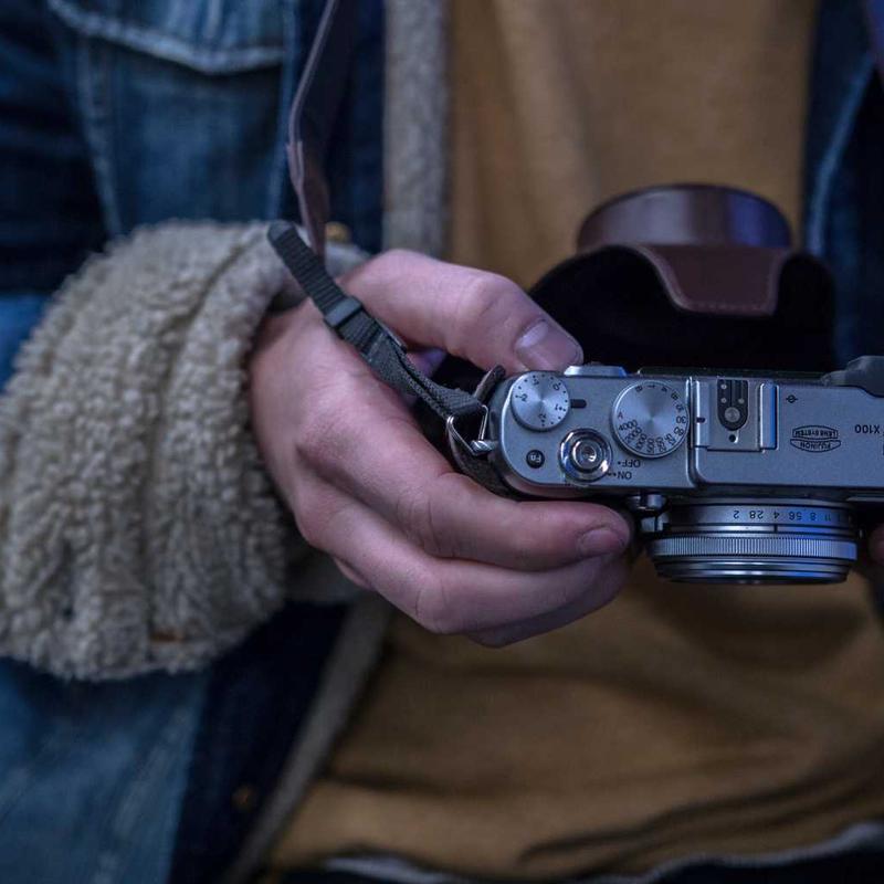 Hai bàn tay cầm một chiếc máy ảnh rangefinder